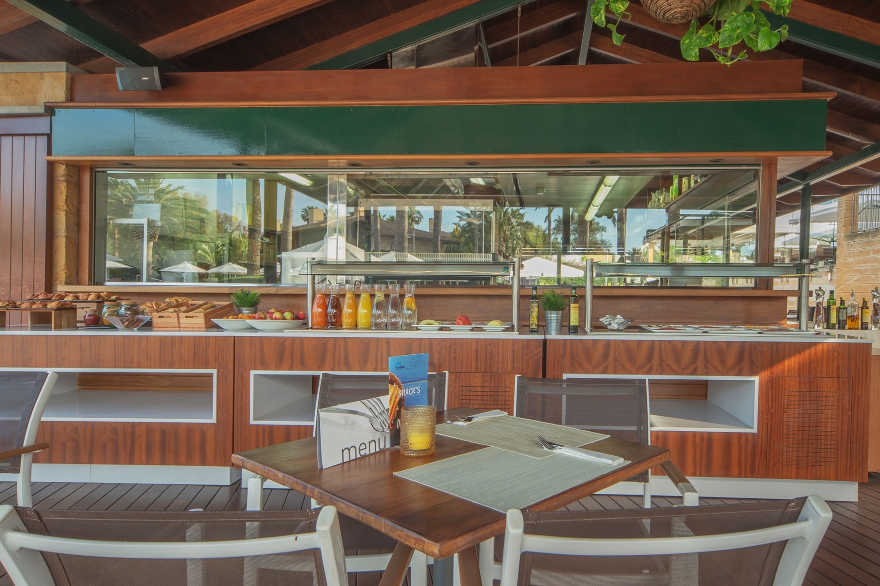 Ein Restaurant mit Holztresen, einer Speisekarte und Außenbereich.