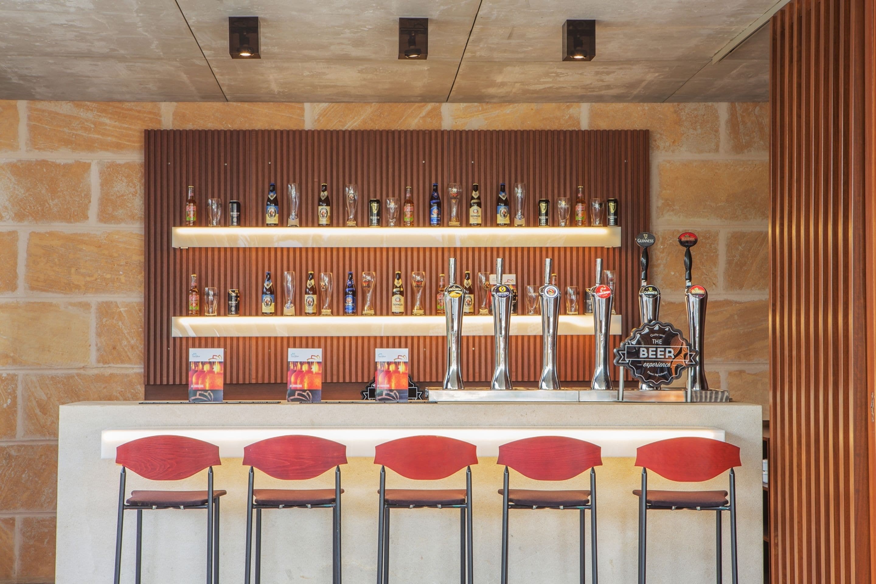 Un espace bar avec plusieurs étagères remplies de bouteilles et un robinet portant l’inscription « La bière ».