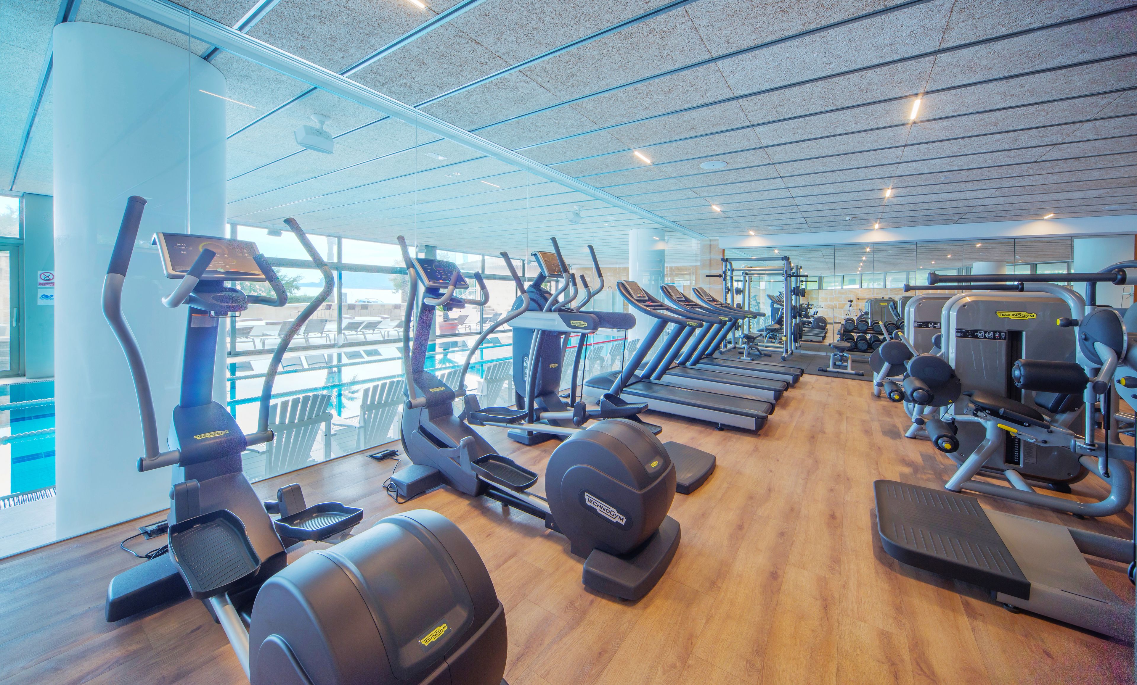 Une salle de sport équipée de tapis de course, de vélos elliptiques et de matériel de musculation.