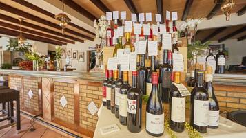 Un espacio para catas de vino con varias botellas exhibidas sobre una mesa, cada una con etiqueta y precio.