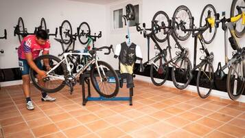 A room with bicycles mounted on the wall and a person adjusting a bike.