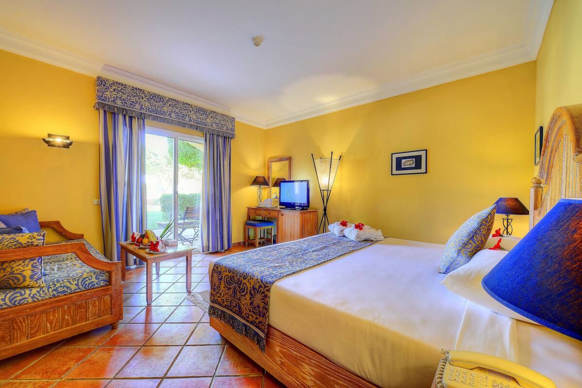 Une chambre d’hôtel comprenant un lit, un canapé, un bureau avec une télévision et un téléphone.