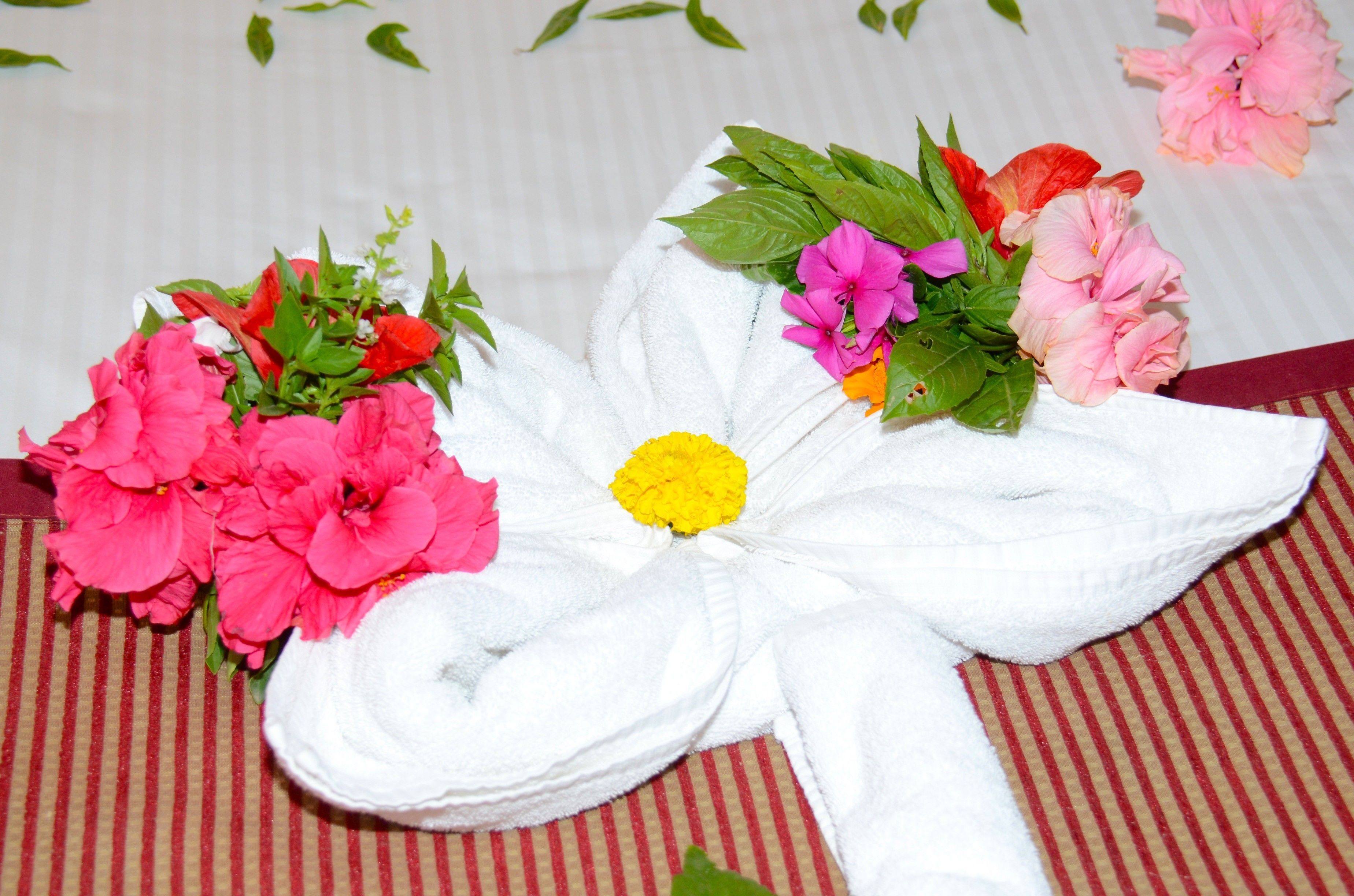 A towel with a floral design, placed on a striped surface.