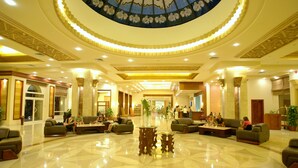 A spacious lobby with a high ceiling, a central floral arrangement, and multiple seating areas. - Rehana Royal Beach Resort - Aquapark & Spa - Families & Couples Only -  Premium Ultra All-Inclusive 24H (Sharm El Sheikh)