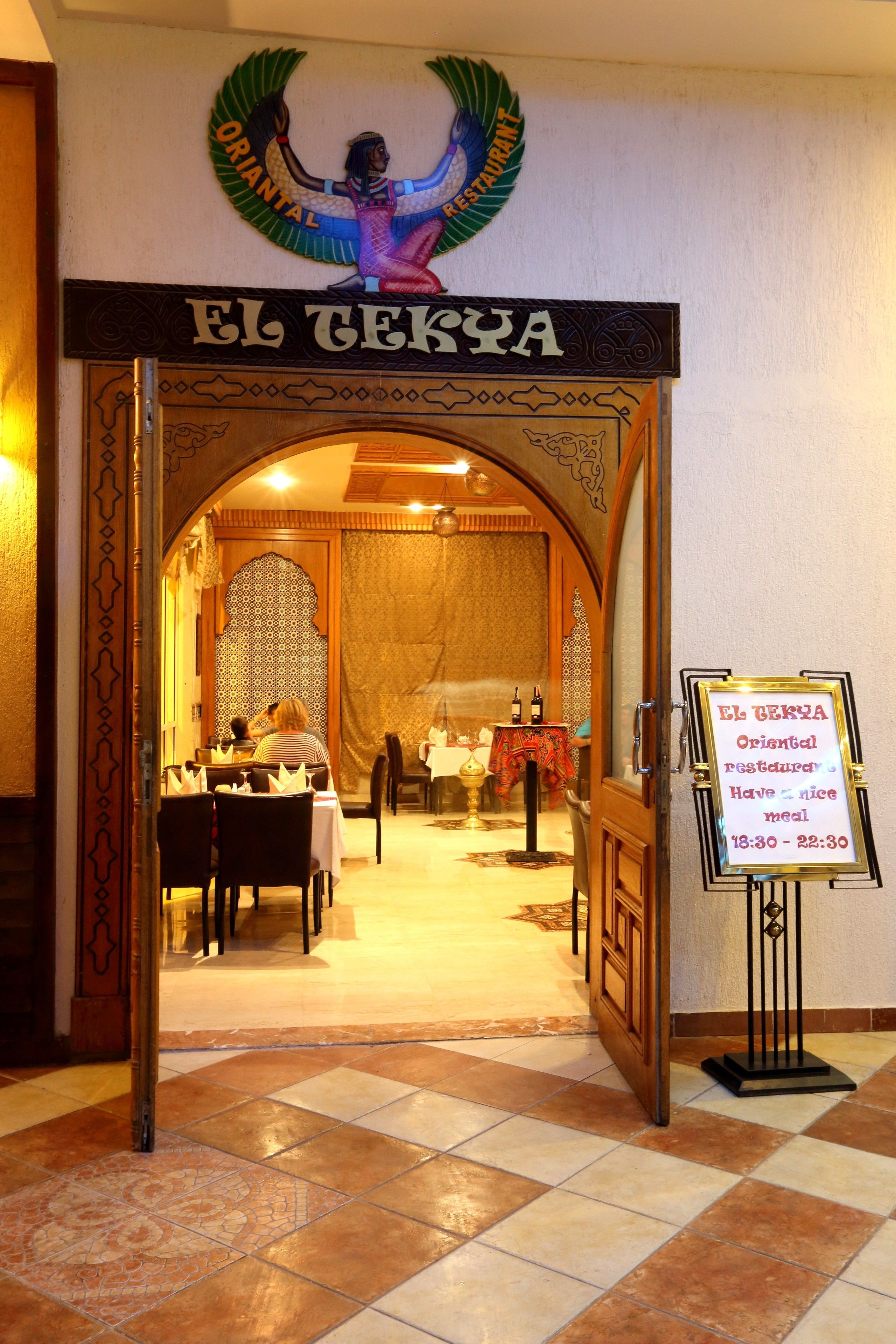 La entrada a El Tekla, un restaurante oriental con un letrero que indica que ofrece una buena cena de 18:30 a 22:30.