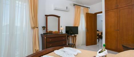 A hotel room with a bed, a TV, a dresser, and a wardrobe.