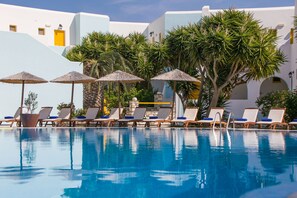 Una piscina al aire libre, sillones reclinables de piscina