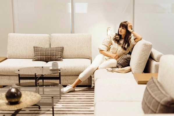 A modern living room with a sofa, a coffee table, and a patterned rug.