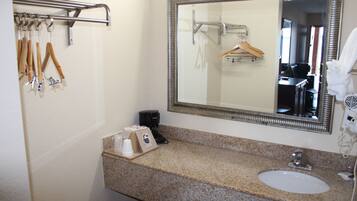 A bathroom with a granite countertop, a sink, a mirror, and a towel rack.