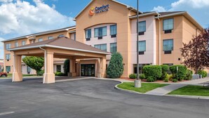 Ett Comfort Inn & Suites-hotell med en inglasad entré, flera fönster och en parkeringsplats.