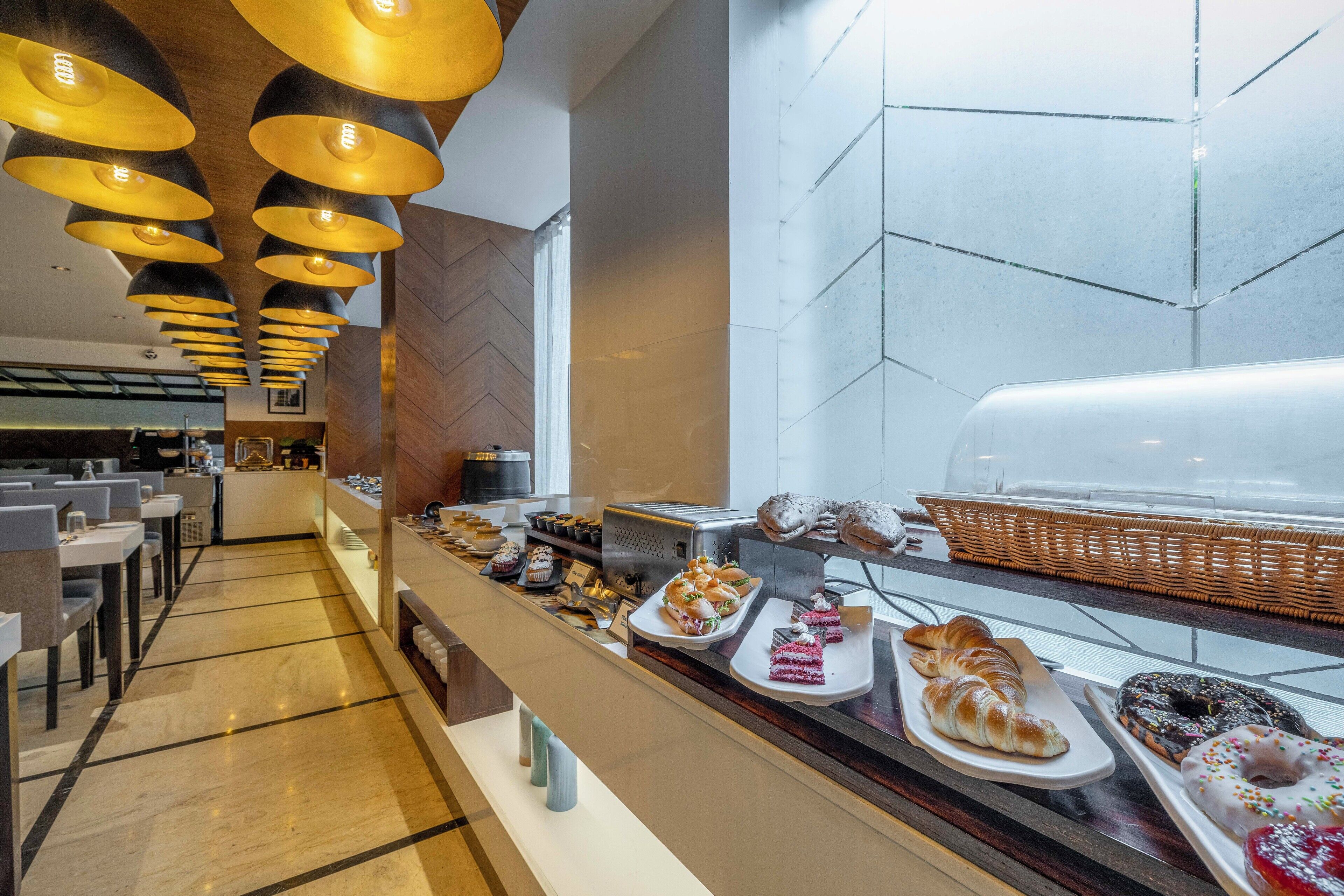 A buffet area with various pastries and desserts displayed on plates and trays.