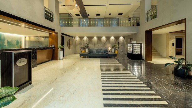 A spacious lobby with a reception desk, a seating area, and a staircase leading to an upper level. - Citrine Hotel (Bengaluru)