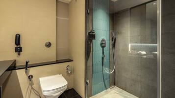 Un baño moderno con inodoro, ducha con puerta de vidrio y lavamanos.