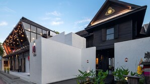 Un edificio moderno con techo inclinado, un amplio ventanal y un emblema solar decorativo en el techo.
