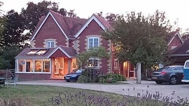 A large, two-story house with a prominent gabled roof and a covered porch. - Manston Guest House (Sturminster Newton)