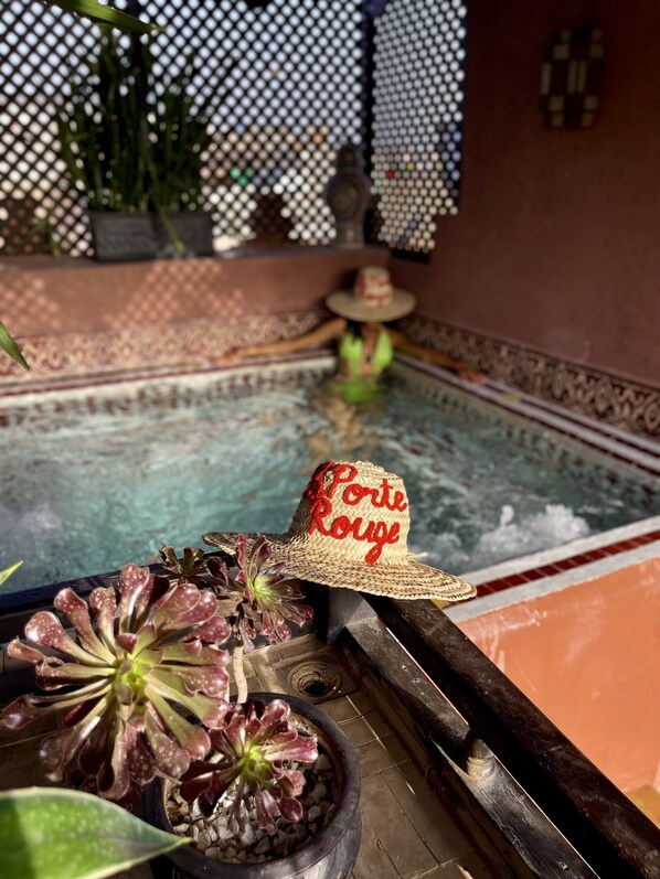A pool area with a hat labeled "Porte Rouge" and decorative plants. - Riad La Porte Rouge By La Siredrah (Marrakech)