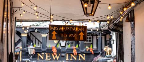 A sign for a bars and restaurant with a directional arrow pointing to the right, indicating the way to the establishment.