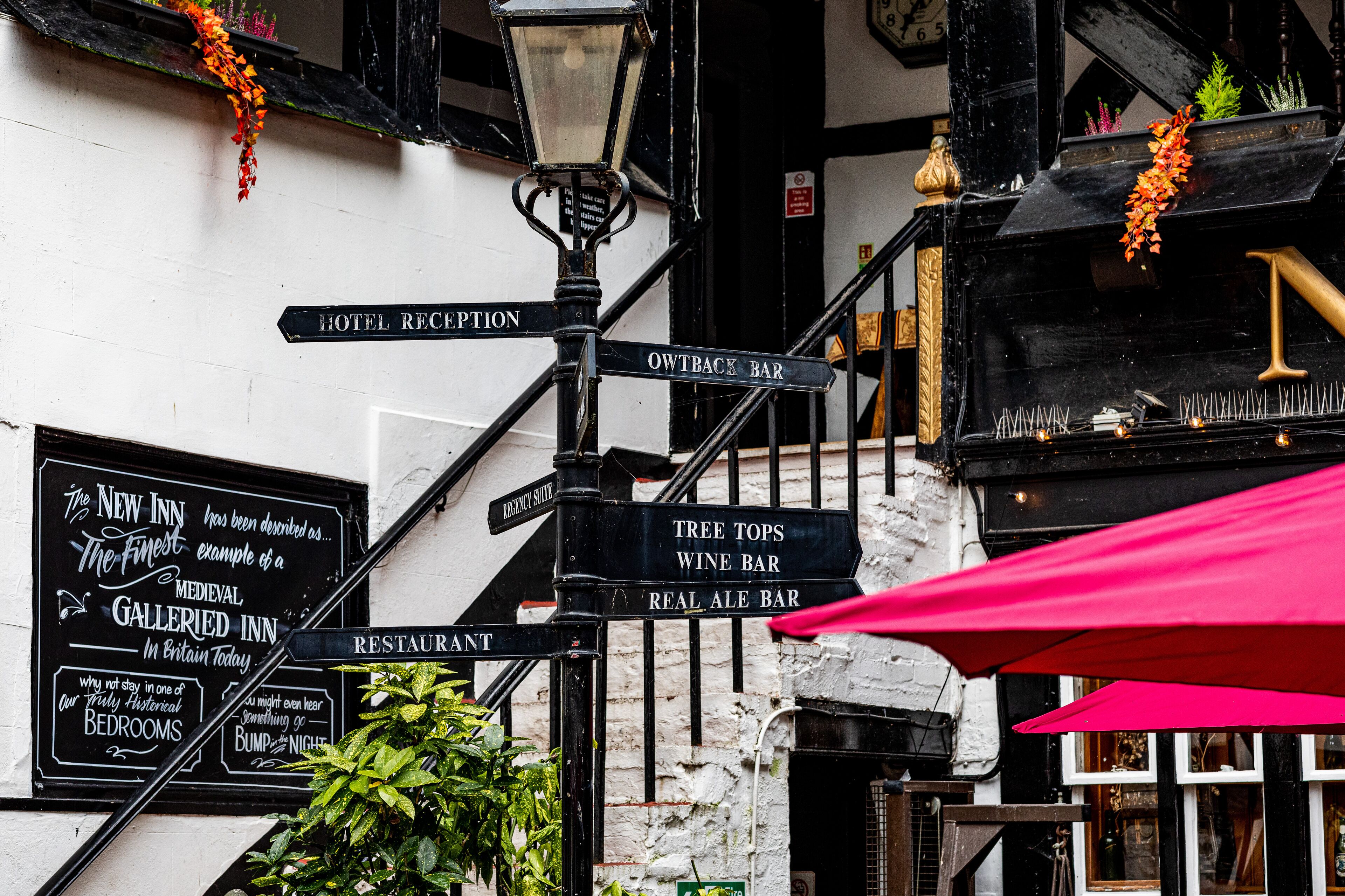 A hotel reception sign, an outhouse bar sign, a tree tops wine bar sign, and a real ale bar sign.