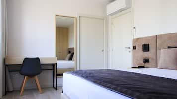 A bedroom with a bed, a desk, and a chair.