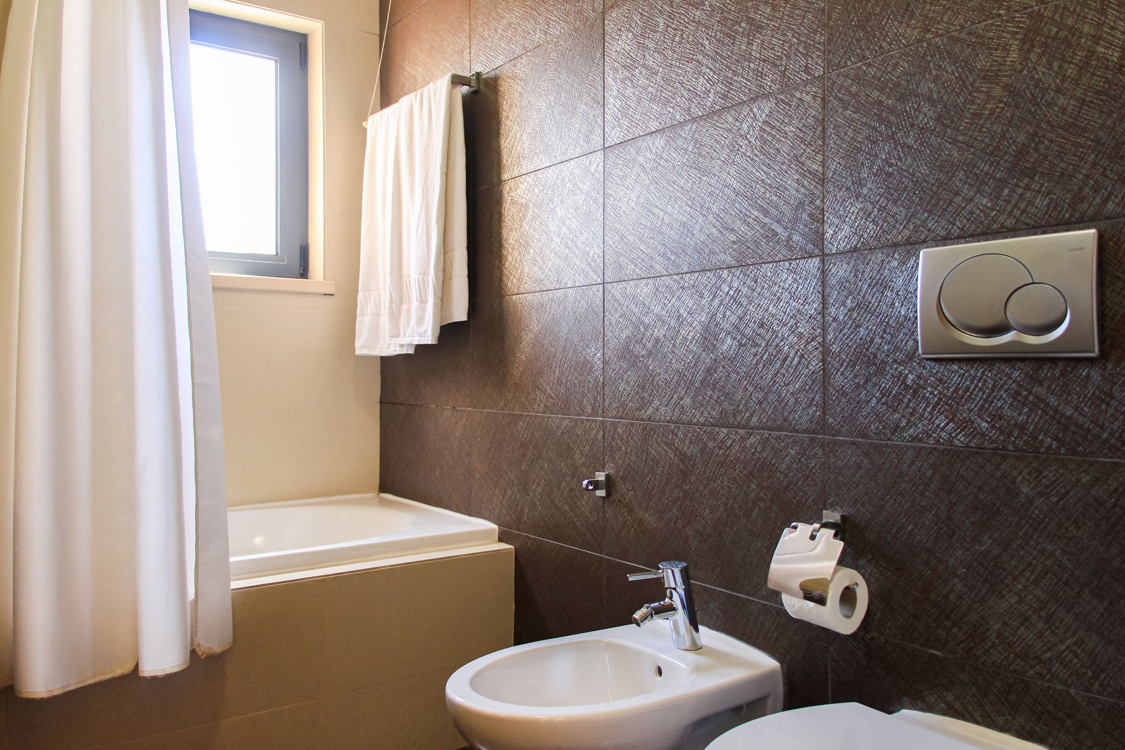 Un baño con bañera, lavabo e inodoro.