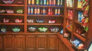 A snack display area with various packaged snacks and a trash bin.