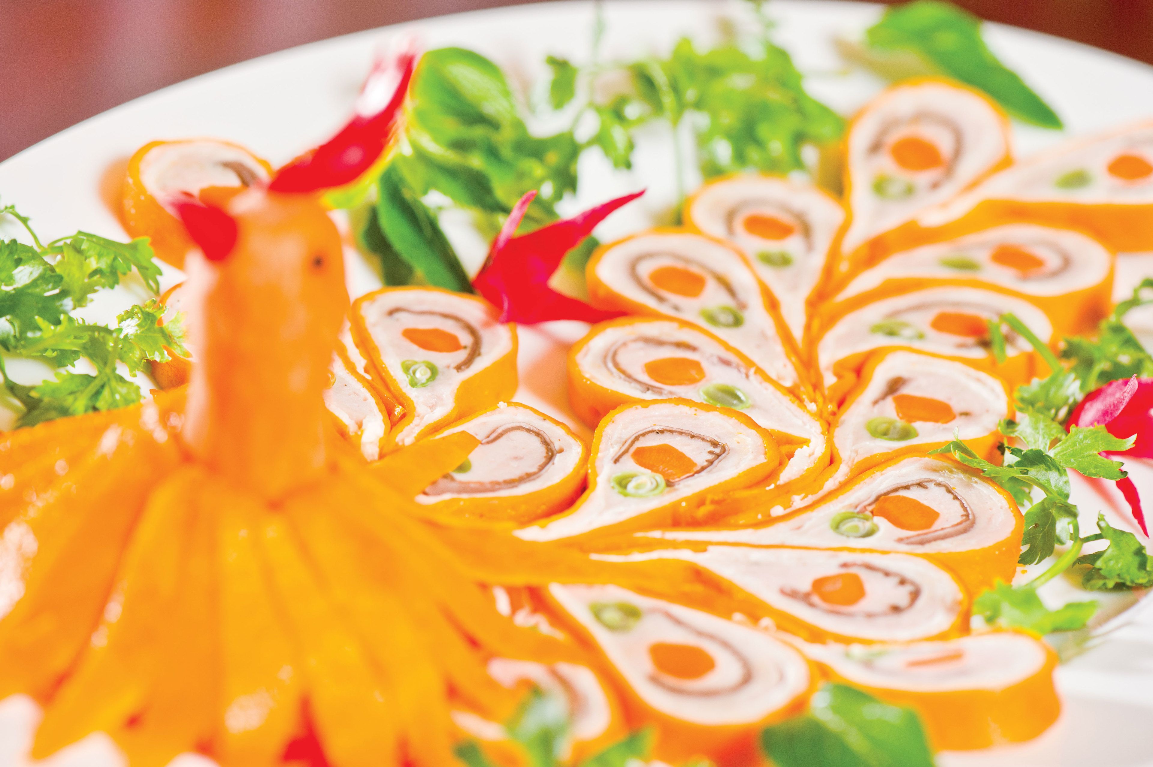 A plate of sliced meat rolls with vegetables.