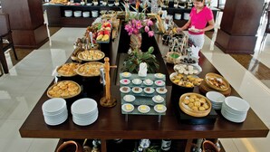 Ein reichhaltiges Buffet mit verschiedenen Speisen und einer Blumenarragemement.