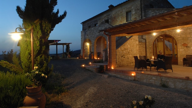 A rustic stone building with a covered patio area featuring outdoor seating. - Agrihotel Il Palagetto (Volterra)