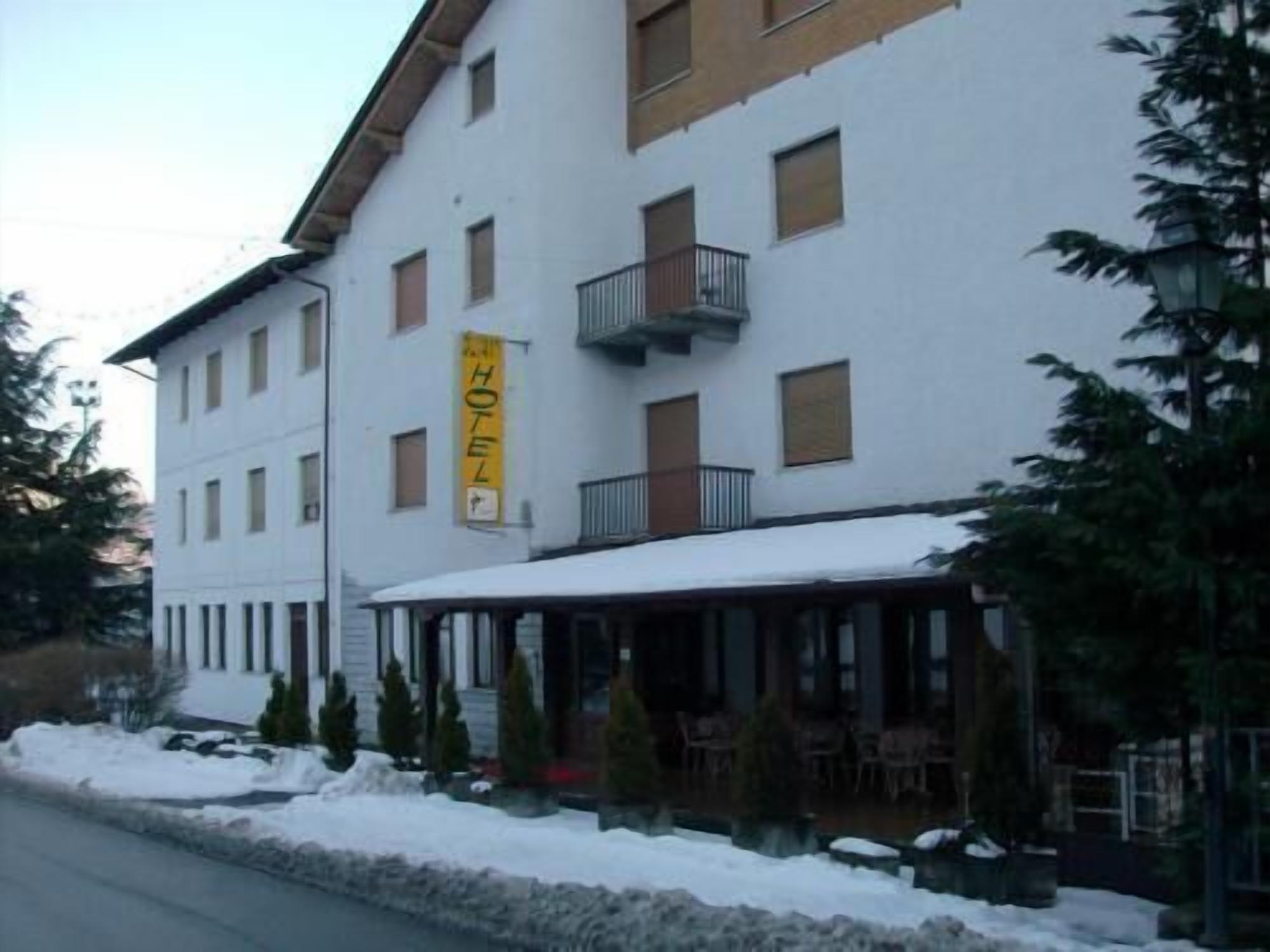 Un hotel con fachada blanca, varias ventanas y un balcón.