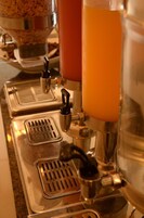 Una cafetera con varios dispensadores y un tazón de cereal.