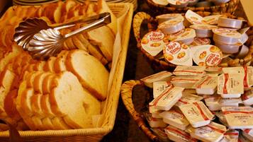 A buffet with bread, cheese, and yogurt.