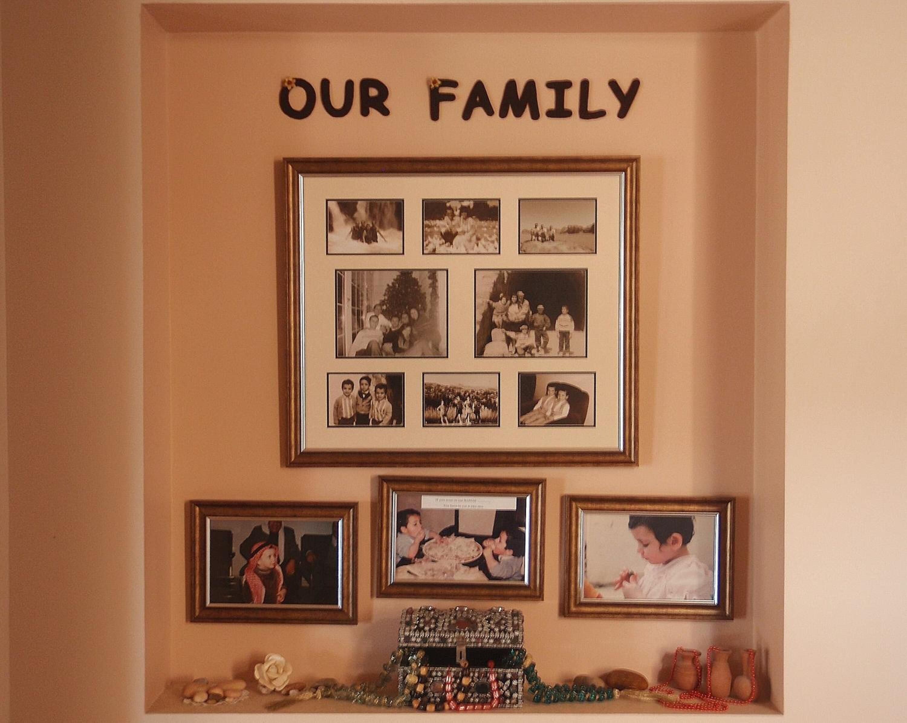 Uma colagem de fotos de família em uma parede, com a legenda 'NOSSAS FAMÍLIAS' em cima.