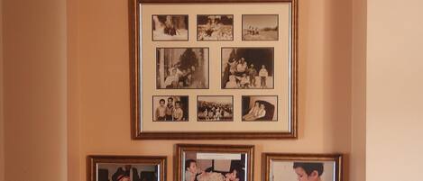 Uma colagem de fotos de família em uma parede, com a legenda 'NOSSAS FAMÍLIAS' em cima.