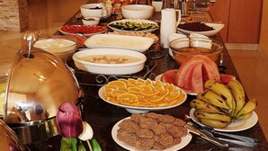 A buffet table with various food items and a large cake. - Mosaic City Hotel (Madaba)