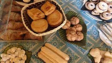 A table with various baked goods including pastries, cookies, and bread.