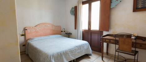 A bedroom with a bed, a desk, and a chair.