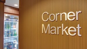 A sign for 'Corner Market' with a refrigerated display case in the background. - Fairfield by Marriott Titusville Kennedy Space Center (Titusville)