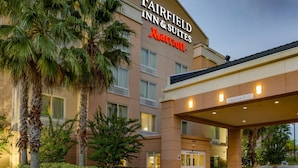 A Fairfield Inn & Suites Marriott hotel with a clear entrance, palm trees, and a well-lit facade. - Fairfield by Marriott Titusville Kennedy Space Center (Titusville)