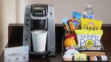 A coffee maker, a welcome sign, and a tray with snacks and condiments.