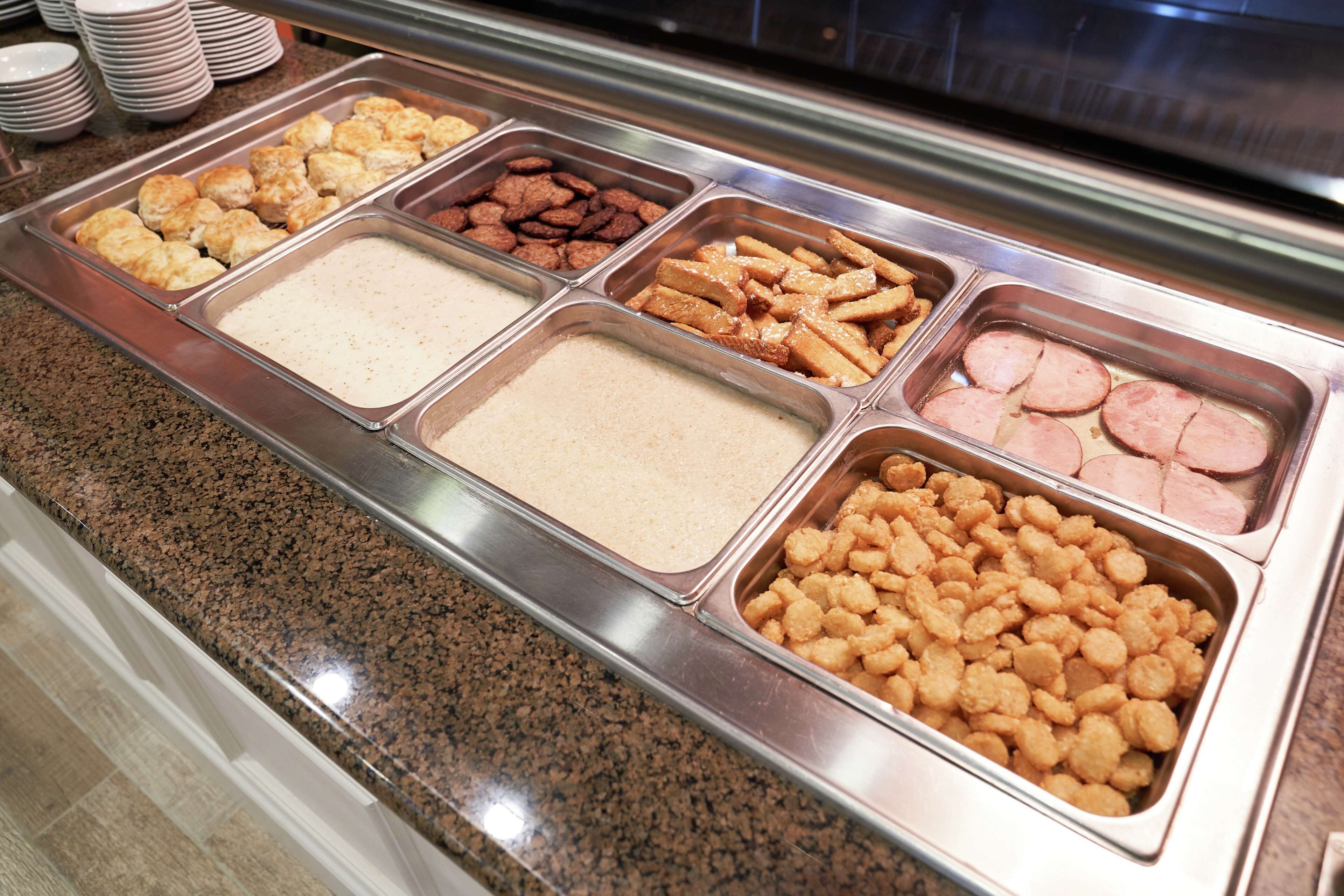 Un buffet proposant une variété d’aliments, notamment des biscuits, des noix, des frites et de la viande.