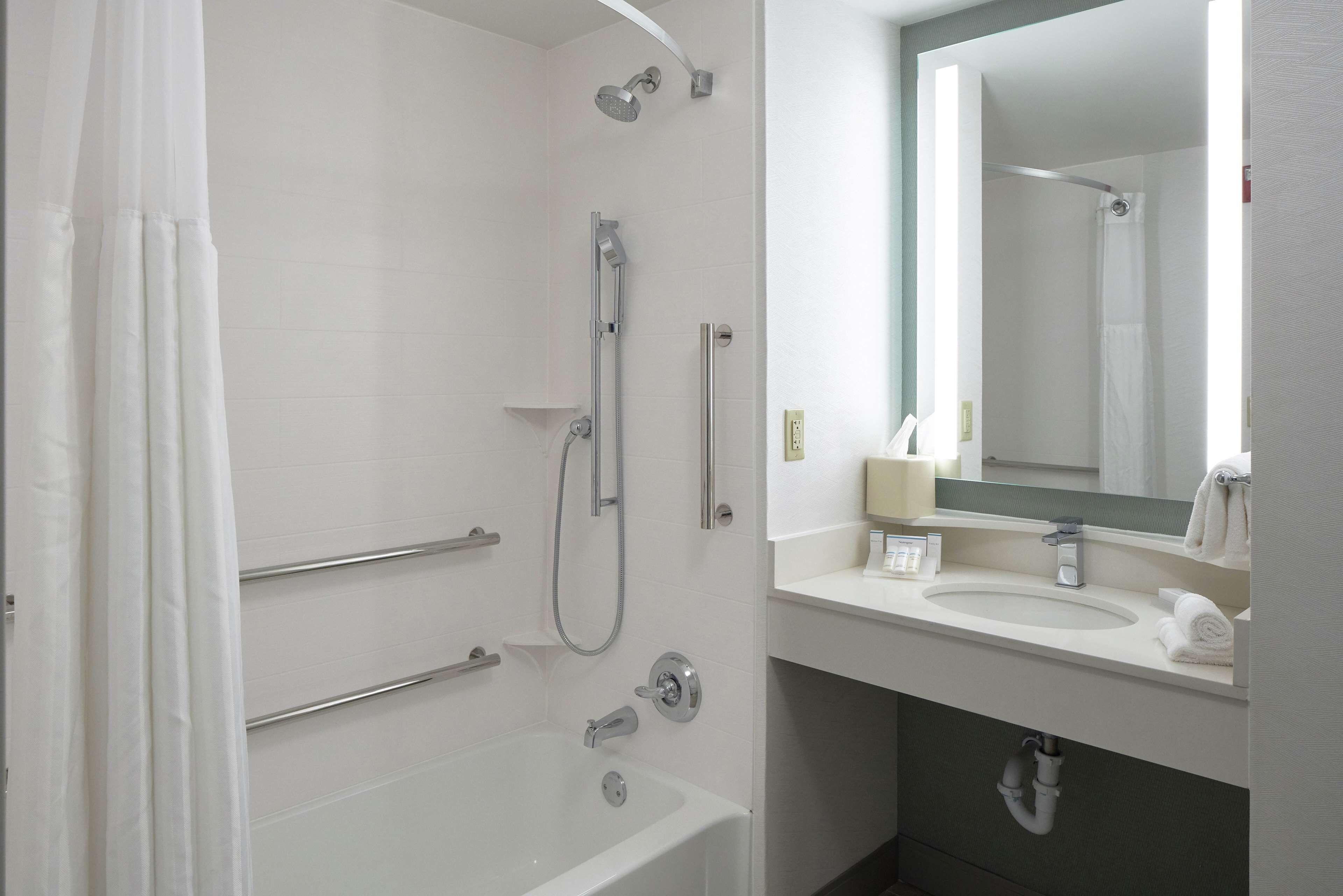 Un baño moderno con ducha, bañera y lavamanos.