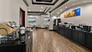 A modern kitchen with a long counter, a coffee machine, and a rice cooker.