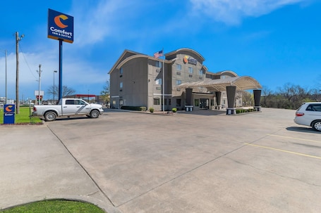 A Comfort Inn & Suites hotel with a parking lot, a flag, and a sign.. Comfort Inn & Suites Atoka