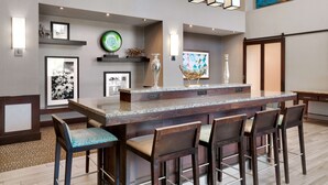 A bar area with a granite countertop, bar stools, and decorative items. - Hampton Inn & Suites Ft. Worth-Burleson (Burleson)