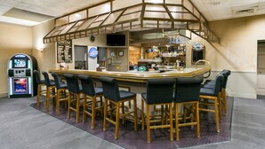 A bar area with a high counter, bar stools, a television, and a jukebox. - Eisenhower Hotel & Conference Center (Gettysburg)