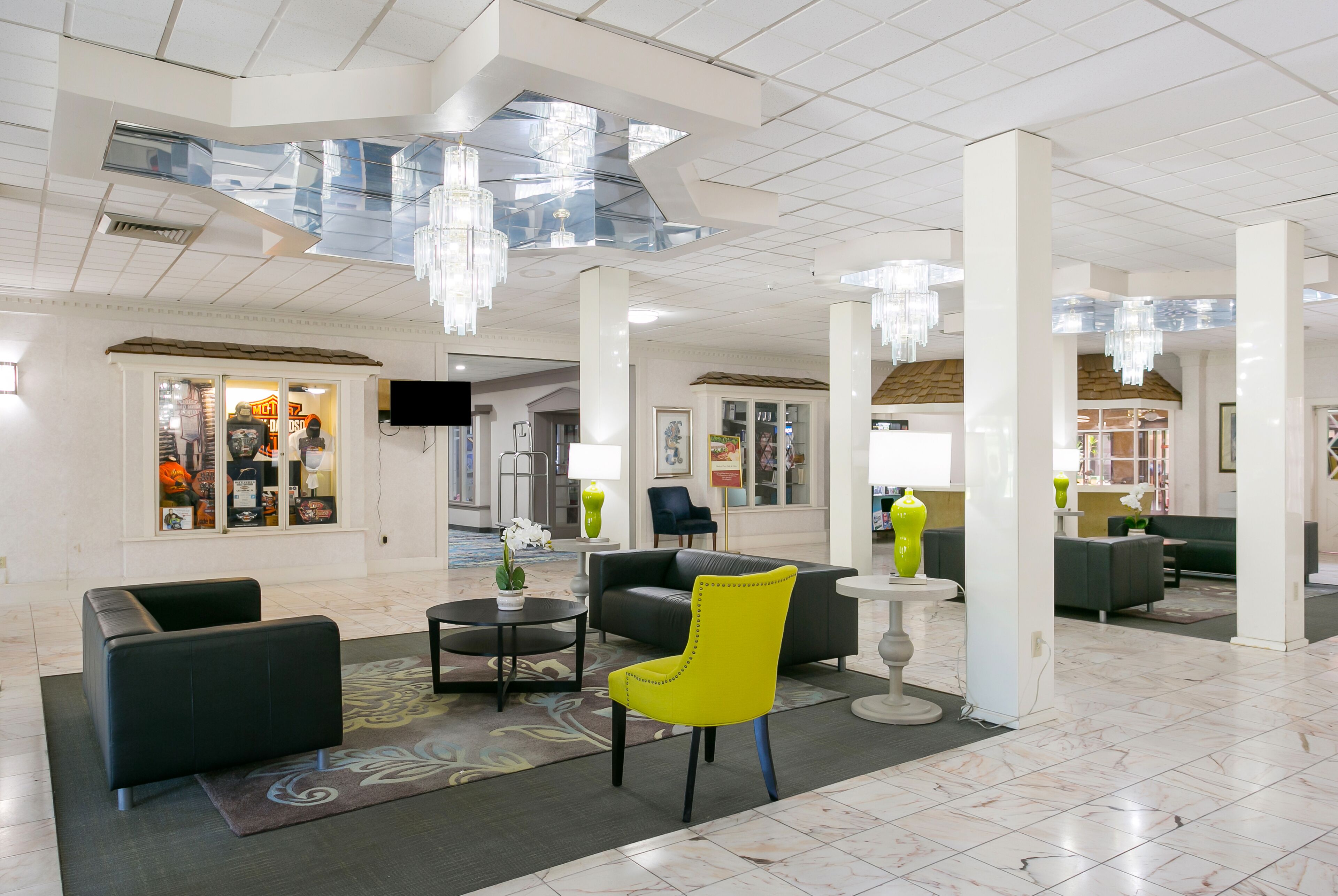 En rummelig lobby med højt til loftet, moderne lysekroner og komfortable siddeområder.