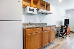 Grand réfrigérateur, micro-ondes, plaque de cuisson, tables à manger