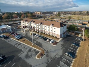 A multi-story hotel with a parking lot in front. - Microtel Inn & Suites by Wyndham Greenville/University Medic (Greenville)