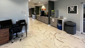 A business center with a reception desk, computer station, and a counter with a coffee machine. - Quality Inn & Suites Lehigh Acres Fort Myers (Lehigh Acres)
