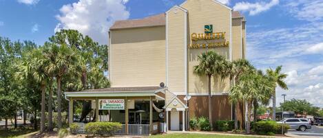 A hotel with a sign for 'Quality Inn & Suites' and a restaurant named 'El Tarasco Mexican Restaurant' in front.